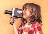 Das Bild zeigt ein Kind, das eine Kamera hält