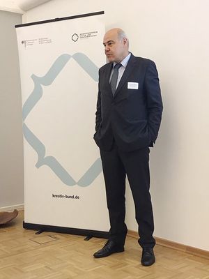 Foto zeigt Bernd-Wolfgang Weismann vor einem Rollup der Kultur- und Kreativwirtschaft im Bundesministerium für Wirtschaft und Energie