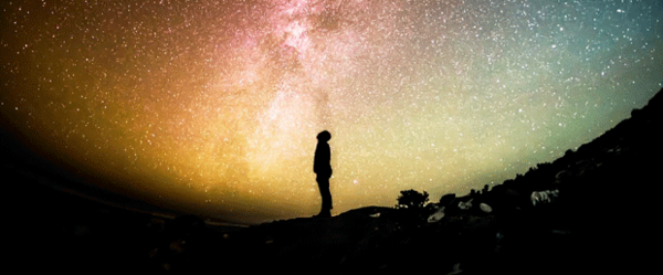 Foto zeigt einen Menschen, der nach oben in den Sternenhimmel schaut