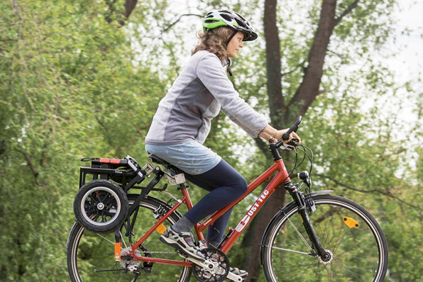 Foto zeigte eine Frau auf einem Fahrrad mit dem faltbaren Trenux-Anhänger