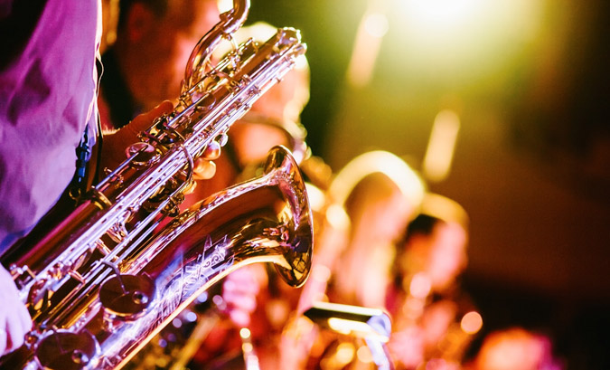 Foto zeigt Musiker mit Saxophon auf einer Bühne